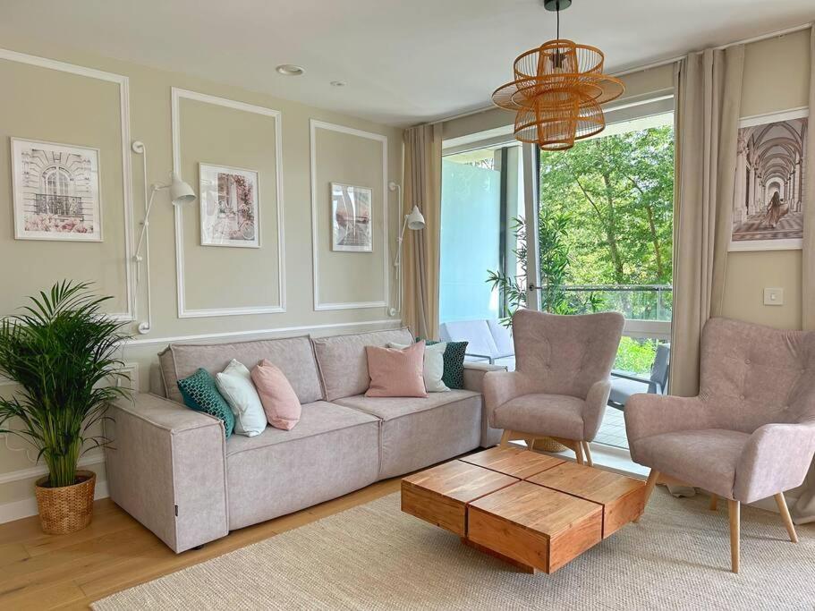 uma sala de estar com um sofá e duas cadeiras em Vick's house em Uxbridge