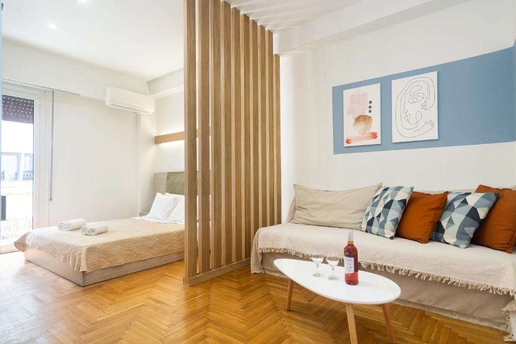 uma sala de estar com uma cama e uma mesa num quarto em KUKAKI ESTATE 2 em Atenas