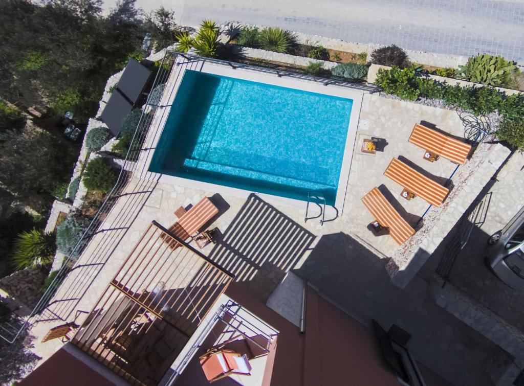 einen Blick über den Pool auf ein Haus in der Unterkunft Villa Kamelicina in Vinišće