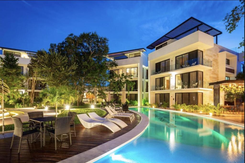 an exterior view of a building with a swimming pool at Increíble estudio G204 con gimnasio incluido by Sandy Powerful in Tulum