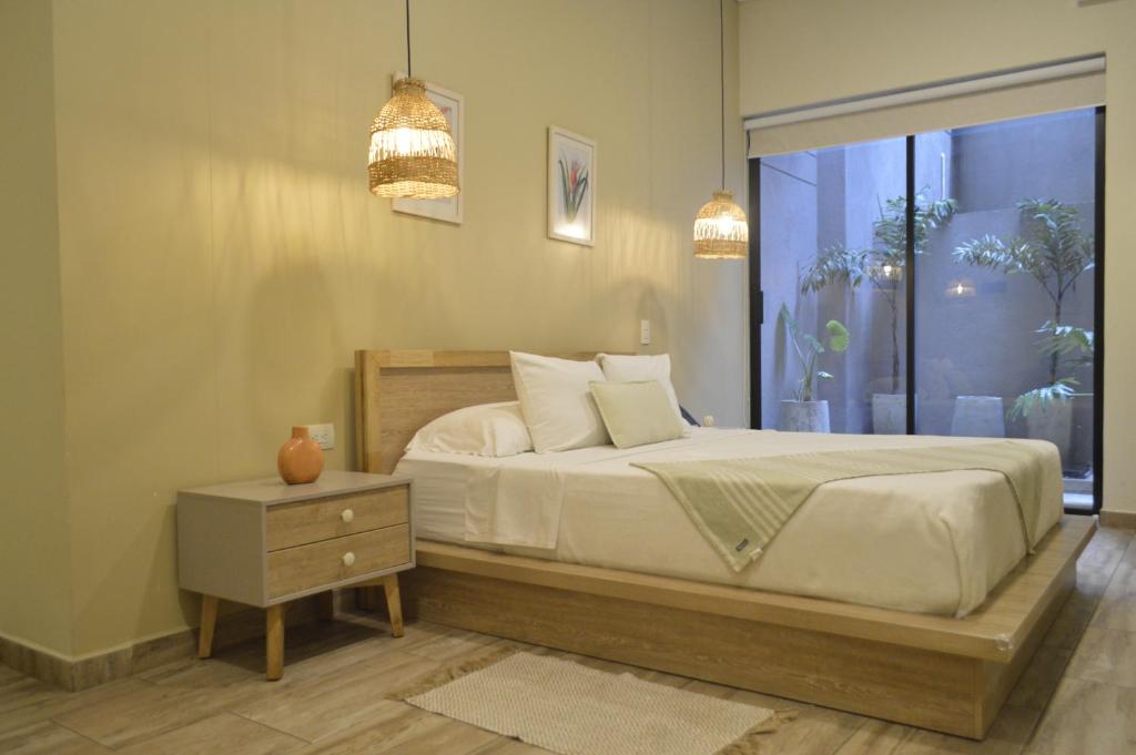a bedroom with a large bed and a window at Mythical Hotel - Boutique in Medellín
