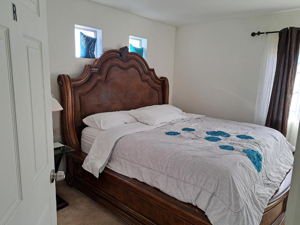 a bed with a wooden headboard in a bedroom at Ram comfort in Denver