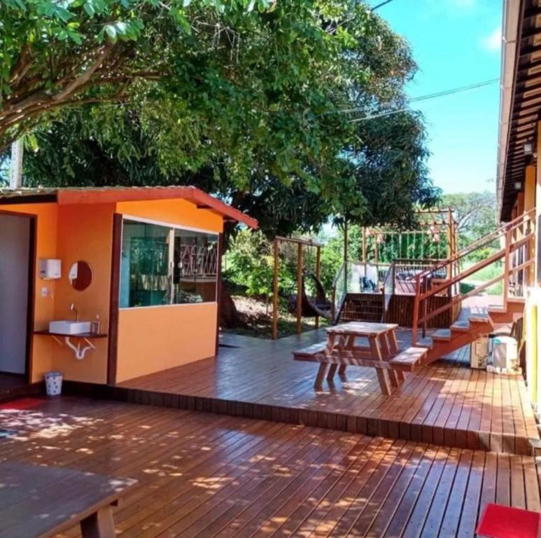 Casa pequeña con terraza con mesa y bancos en Pousada Guedes Noronha, en Fernando de Noronha