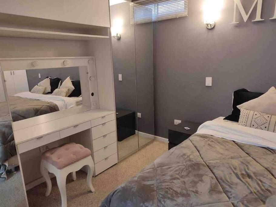 a bedroom with two beds and a mirror at No está disponible in Arequipa