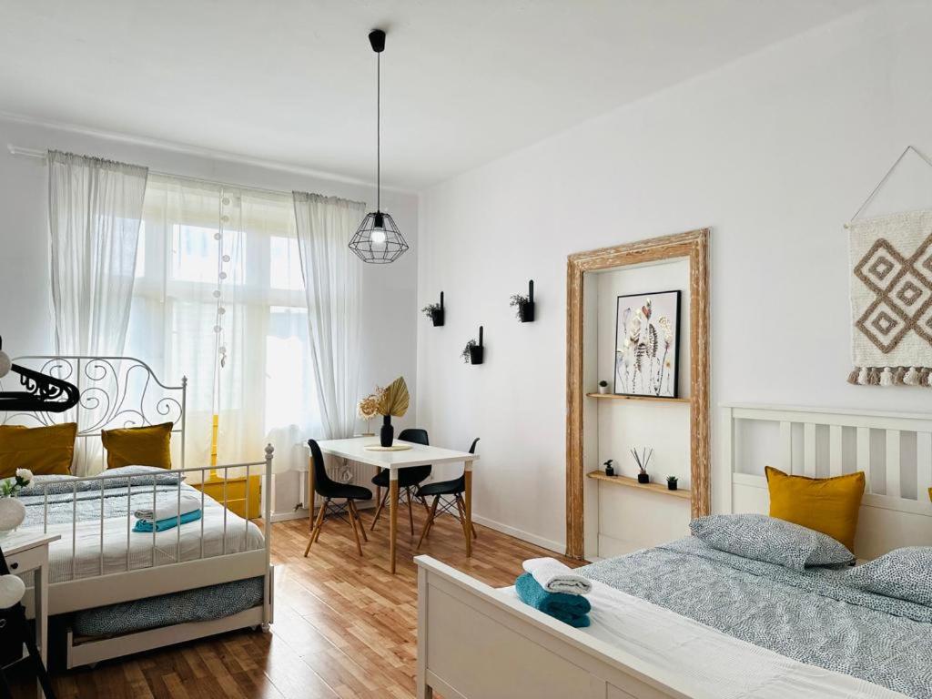 Cozy Apartments and Rooms Katowice في كاتوفيسي: غرفة بسريرين وطاولة فيها