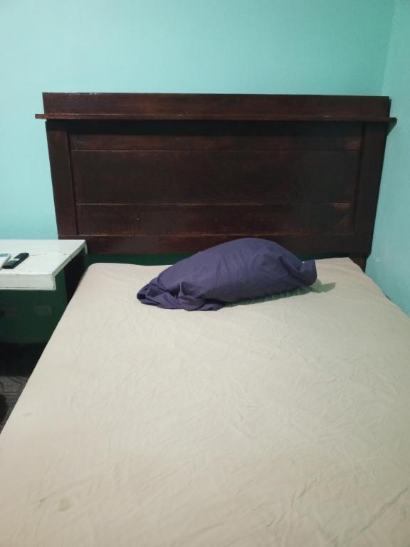 a bed with a wooden headboard and a purple pillow at Recamara confortable en San Nicolás in Monterrey