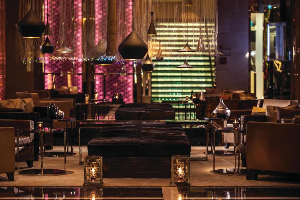 Renaissance Bangkok Ratchaprasong Hotel في بانكوك: مطعم به طاولات وكراسي واضاءات