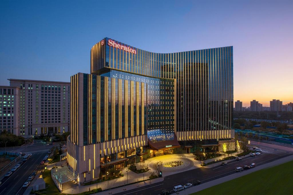 um edifício alto com um sinal em cima em Sheraton Beijing Lize Hotel em Pequim