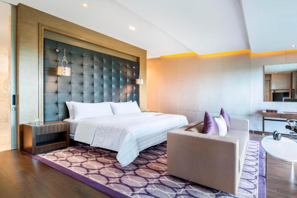 a hotel room with a bed and a couch at Le Meridien Suvarnabhumi, Bangkok Golf Resort and Spa in Bangkok