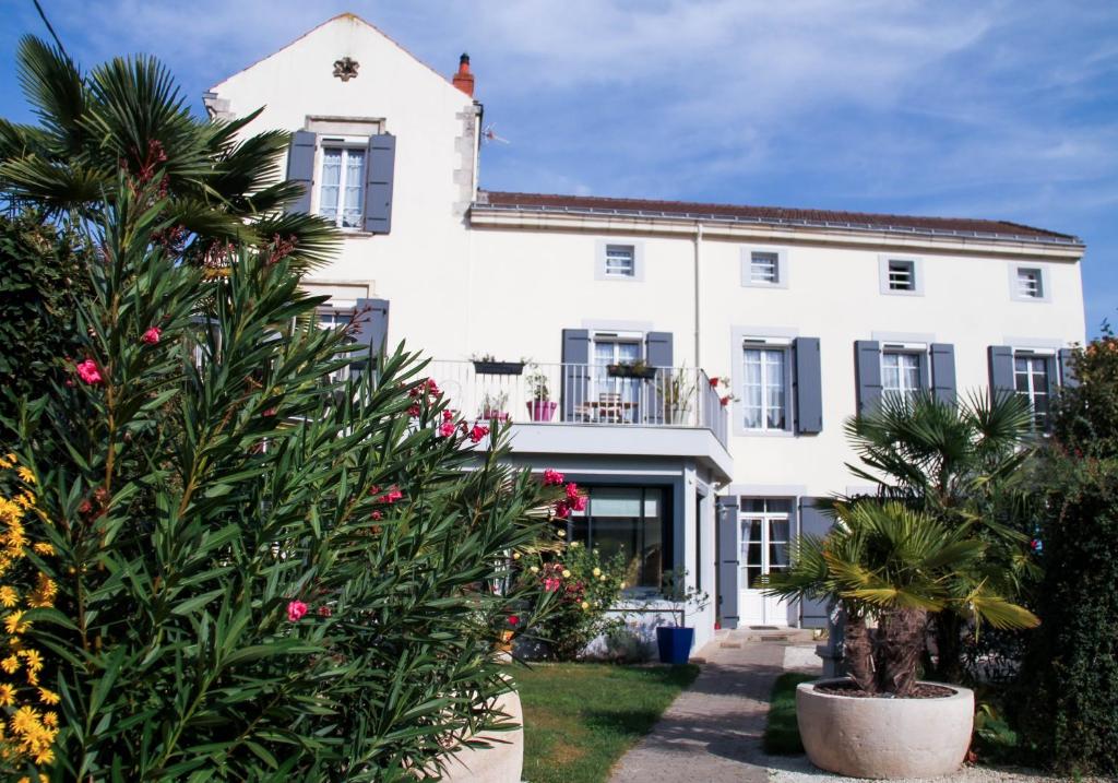 una casa blanca con plantas delante en La Maison de Vénus en Luçon