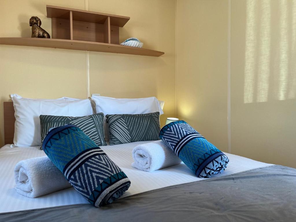 a bed with blue and white pillows on it at Fonte Retreat - Holiday Home in Sandim