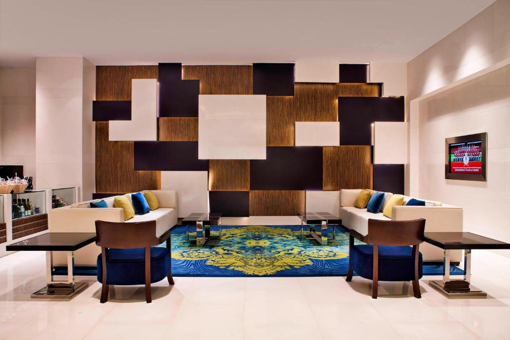 a lobby with chairs and a table and a rug at Courtyard by Marriott Hangzhou Wulin in Hangzhou
