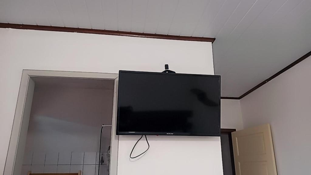 TV de pantalla plana colgada en la pared en Hotel Fenix Salvador en Salvador