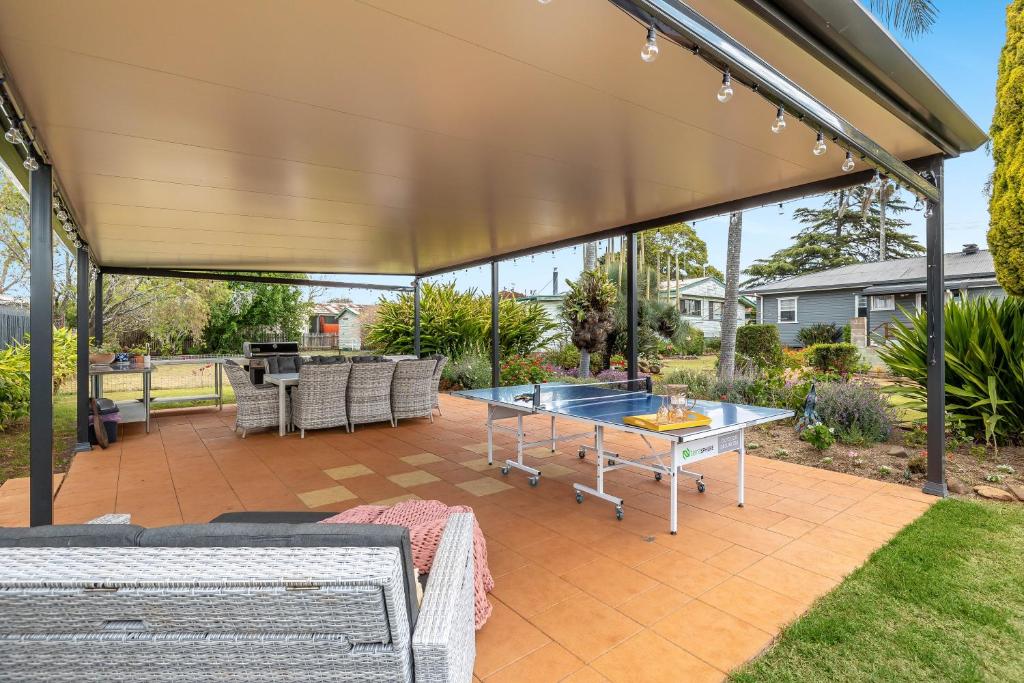 a covered patio with a table and a grill at Grass Tree Cottage! Just Perfect! in Toowoomba