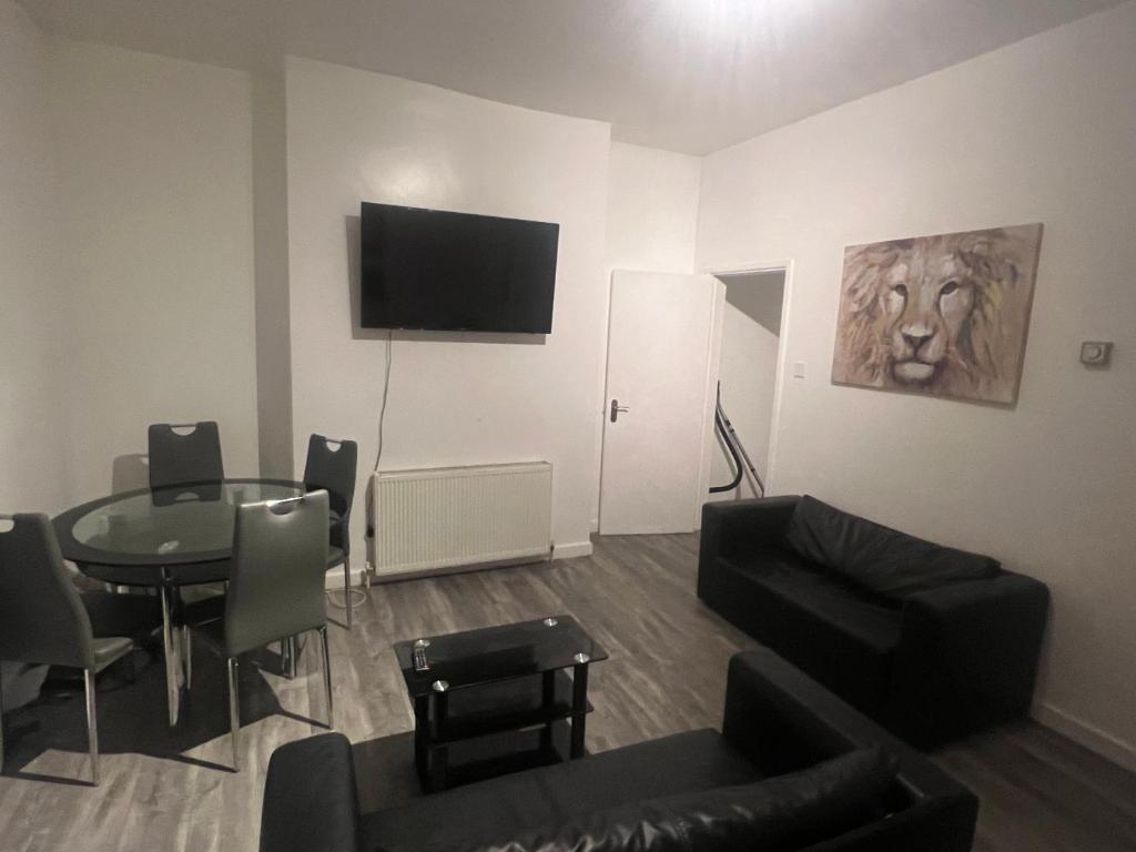 uma sala de estar com uma mesa e uma televisão na parede em Cosy central apartment near Stokes Croft em Bristol