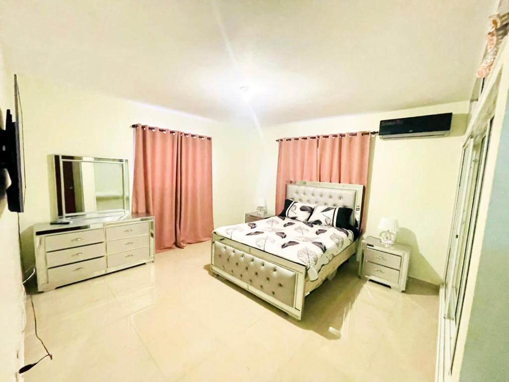 1 dormitorio con 1 cama, vestidor y TV en Oasis de Paz 4, en Jarabacoa