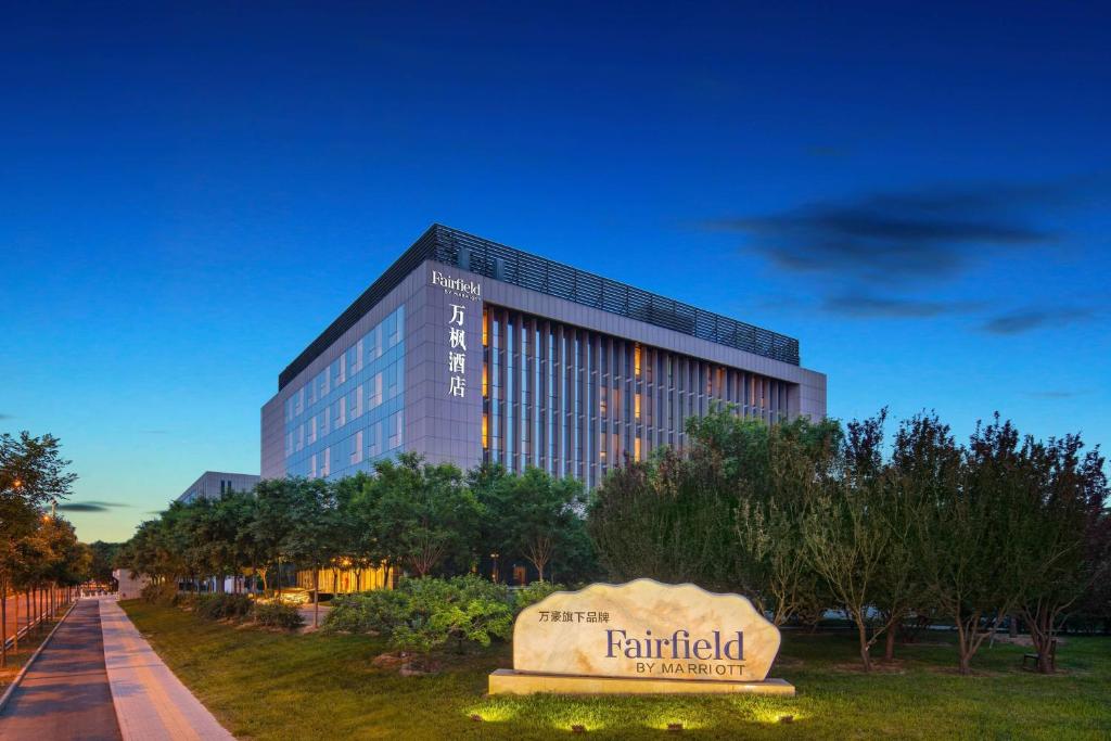 Fairfield by Marriott Beijing Haidian في بكين: مبنى طويل مع علامة أمامه