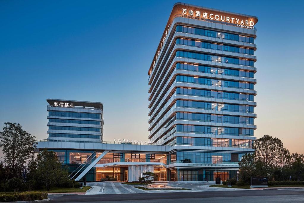 a large office building with a sign on it at Courtyard by Marriott Qinhuangdao West in Qinhuangdao