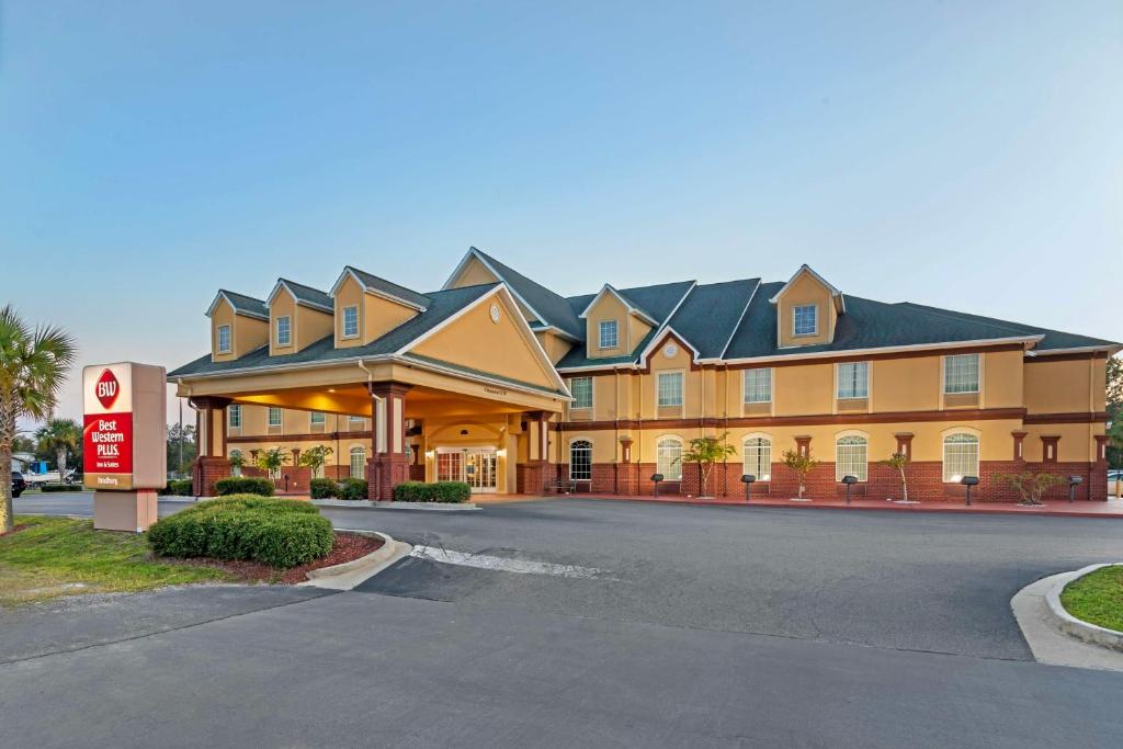 ein großes Gebäude mit einem Schild davor in der Unterkunft Best Western Plus Bradbury Inn and Suites in Waycross