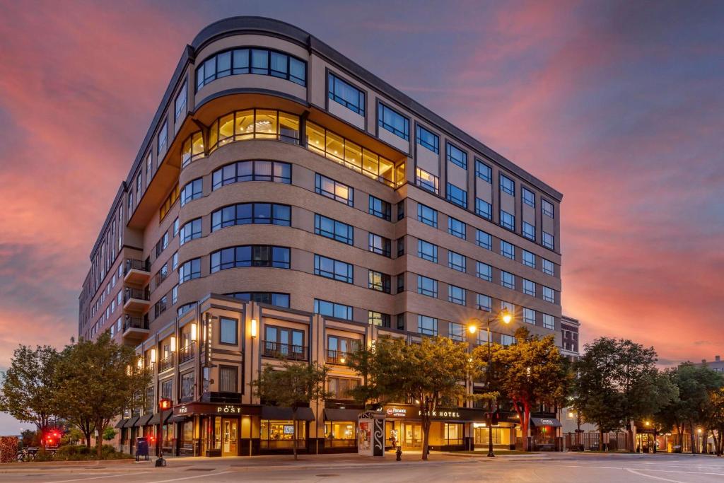 un edificio alto con una puesta de sol en el fondo en Best Western Premier Park Hotel en Madison