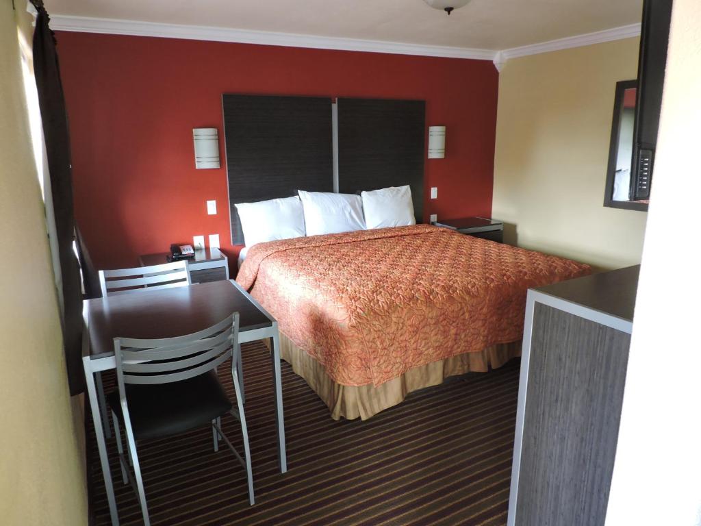 a hotel room with a bed and a desk and a table at Budget Inn Temple in Temple