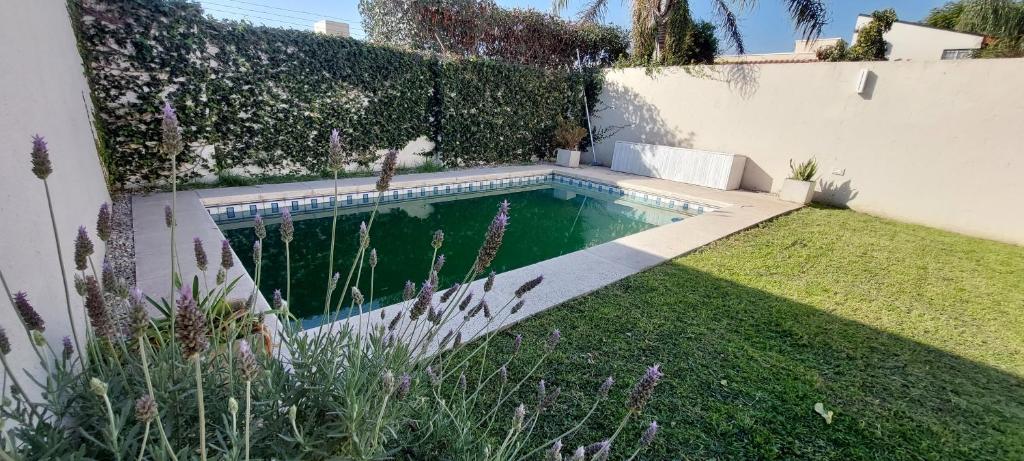 a swimming pool in a yard next to a fence at Casa Pascal, Bº Villa Belgrano in Cordoba