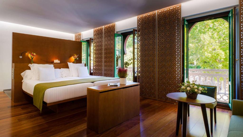 A bed or beds in a room at Alhambra Palace Hotel