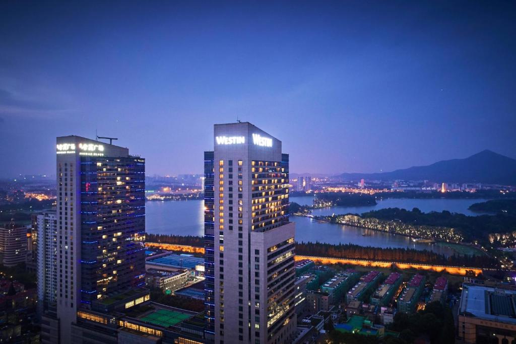 widok na dwa wysokie budynki w mieście w nocy w obiekcie The Westin Nanjing Xuanwu Lake w mieście Nankin