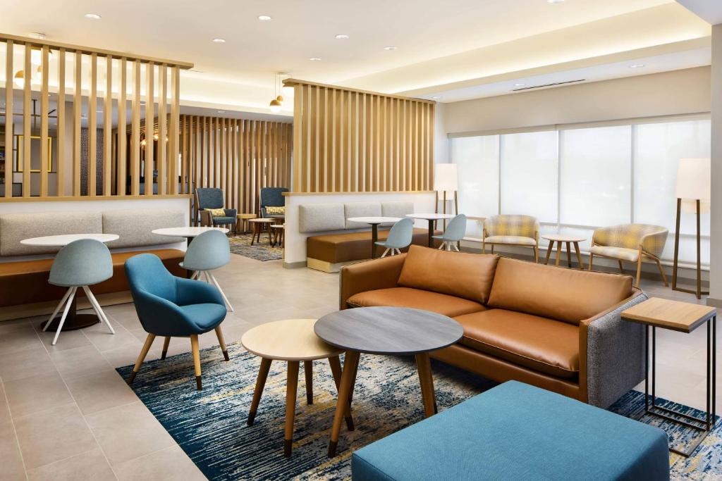 vestíbulo con sofá, mesas y sillas en TownePlace Suites by Marriott Plant City en Plant City