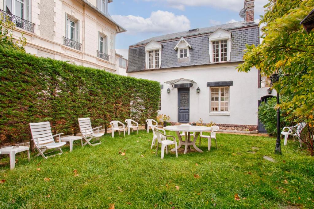 a table and chairs in the yard of a house at Villa Victor Hugo in Deauville