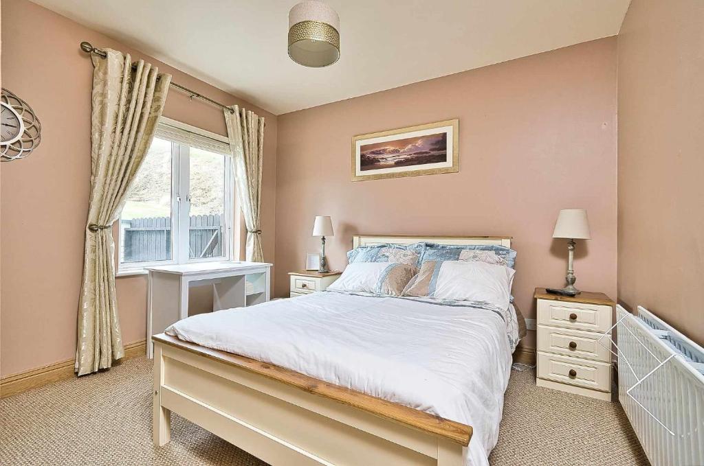 a bedroom with a large bed and a window at Mountain view kingscourt 
