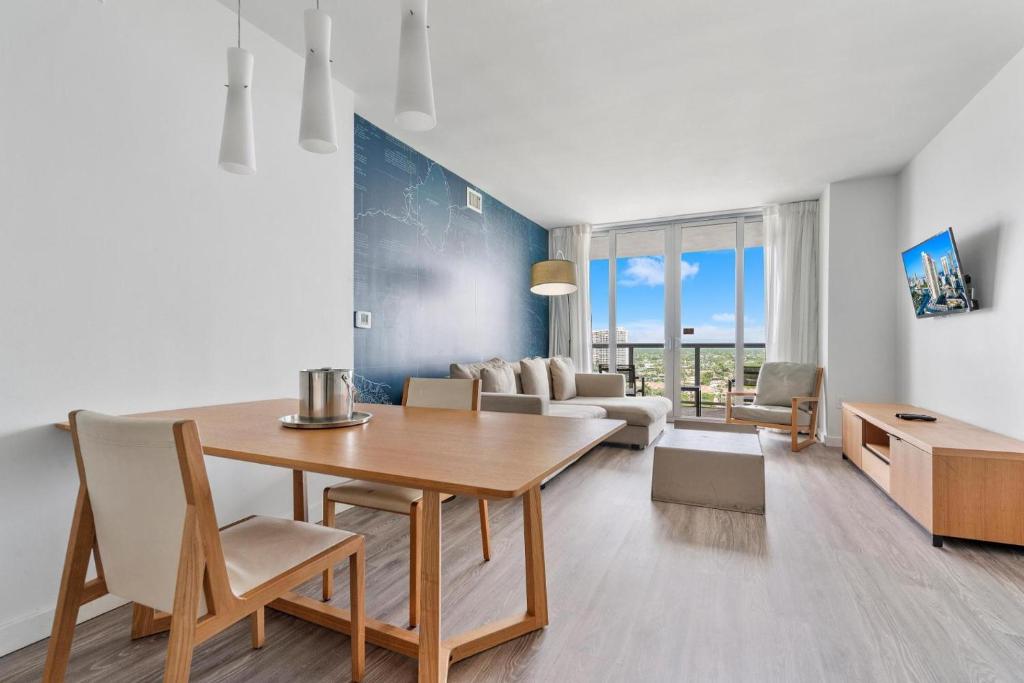 a dining room with a table and a living room at Modern one bedroom rental at Beach Walk Resort 17th floor Miami in Hollywood
