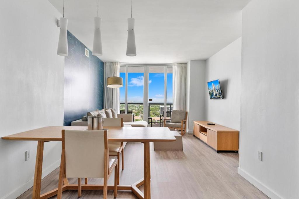 a dining room and living room with a table and chairs at Modern one bedroom rental at Beach Walk resort Miami 18th floor in Hallandale Beach