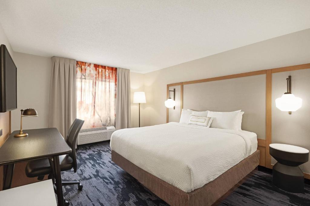 a hotel room with a bed and a desk and a bed sidx sidx at Fairfield Inn by Marriott Warren Niles in Warren