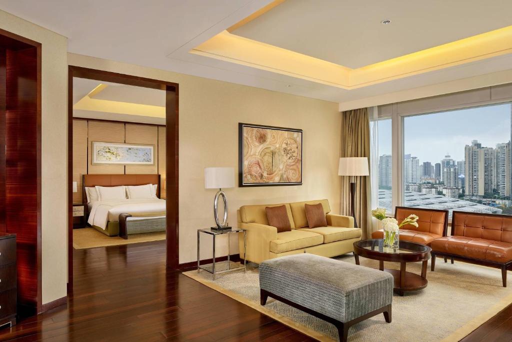 um quarto de hotel com uma cama e uma sala de estar em The Ritz-Carlton, Shenzhen em Shenzhen