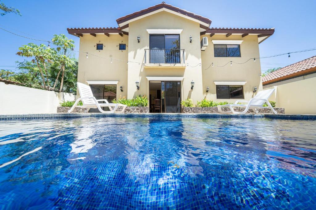a villa with a swimming pool in front of a house at Casa Luz de Luna - Comfortable 3 Br, 3,5 Bath house in Potrero
