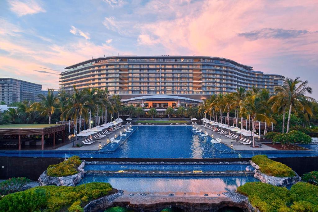 un hotel con piscina frente a un edificio en The Westin Blue Bay Resort & Spa en Lingshui