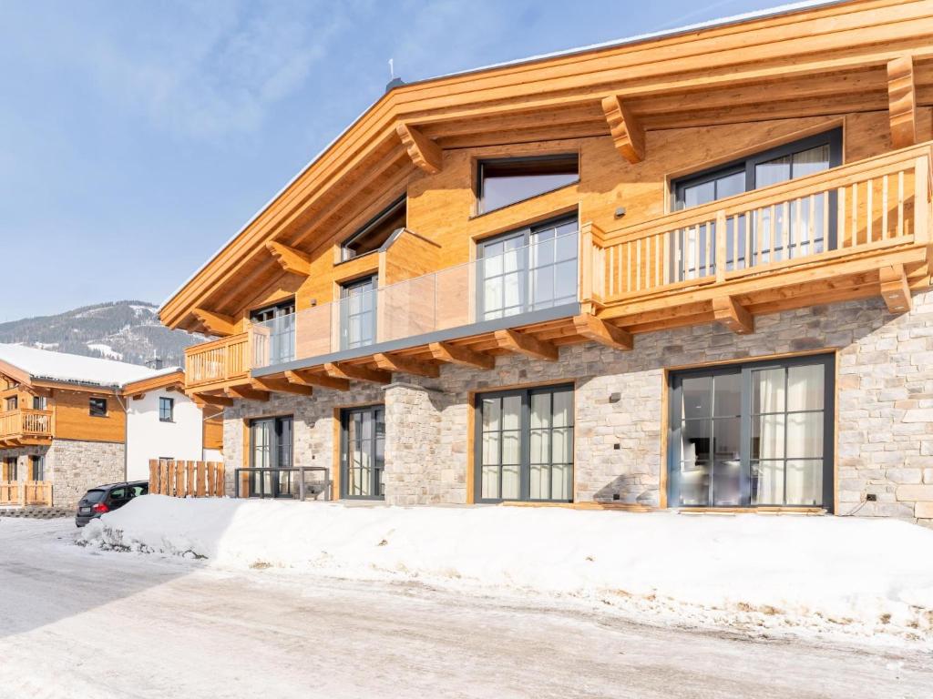 een houten huis met een balkon erboven bij Tauernlodge Carpe Diem in Niedernsill