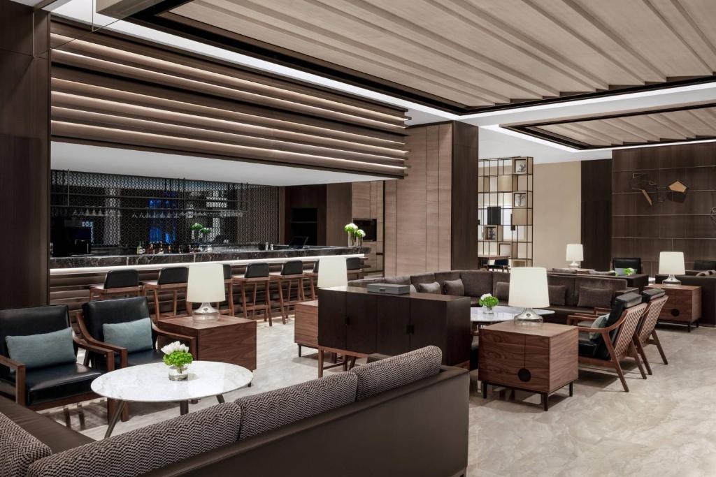 una hall con tavoli e sedie e un bar di Courtyard by Marriott Jiangsu Taizhou a Taizhou