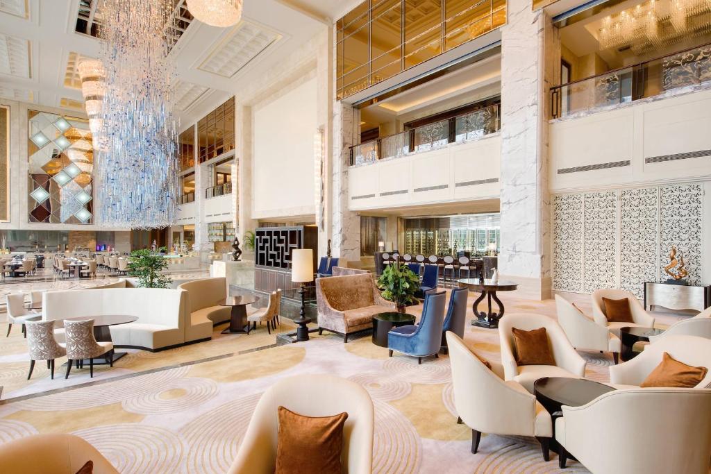 a lobby of a hotel with chairs and tables at Sheraton Qingdao Jiaozhou Hotel in Jiaozhou