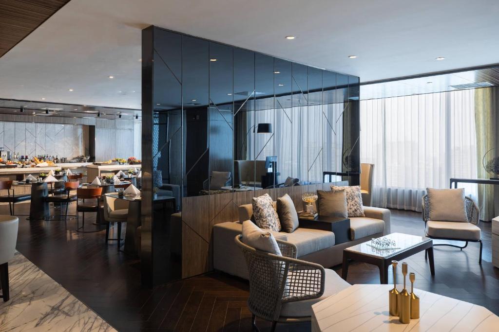 a hotel lobby with couches and tables and a bar at Renaissance Shenyang West Hotel in Shenyang