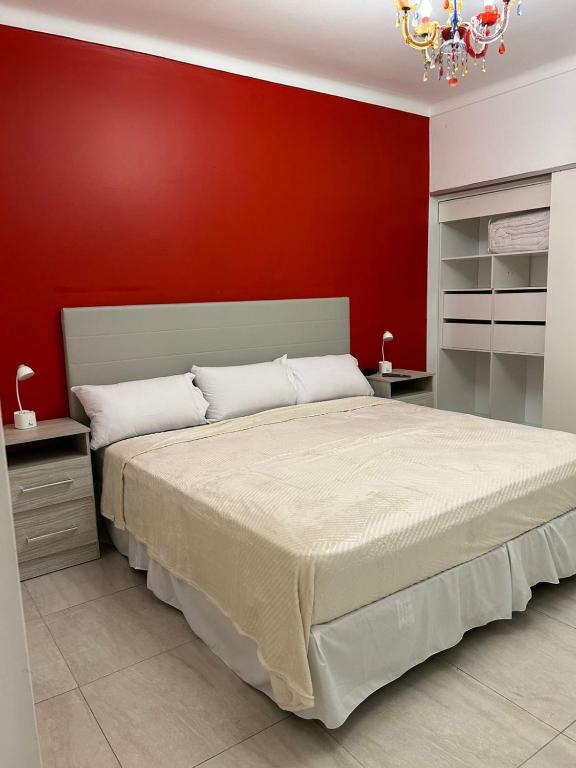 a bedroom with a large bed with a red wall at la florida C in Salta