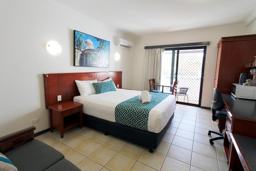 a hotel room with a bed and a balcony at Coffee House Apartment Motel in Rockhampton