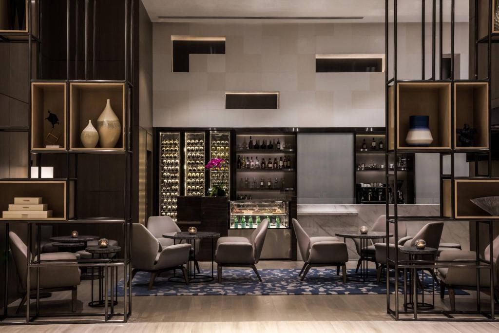 a restaurant with tables and chairs and a wine cellar at Courtyard by Marriott Tianjin Hongqiao in Tianjin