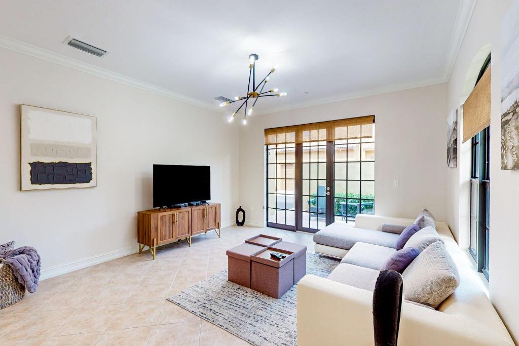 a living room with a couch and a tv at Yuba Oasis in Lely Resort
