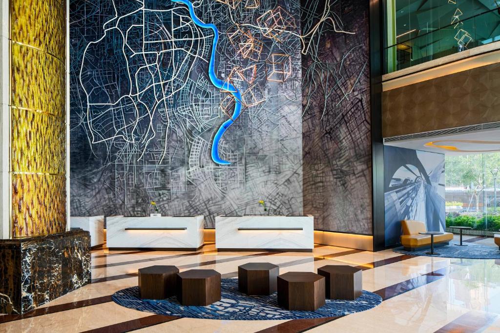 a lobby with stools in front of a wall at Renaissance Shenzhen Luohu Hotel in Shenzhen