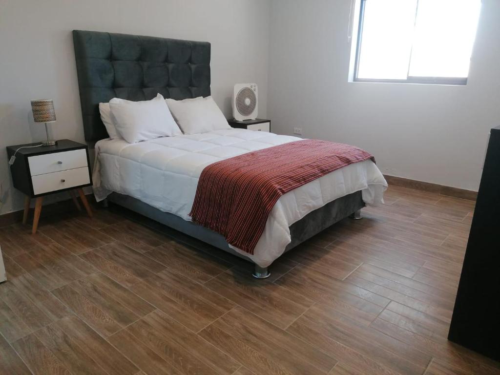 um quarto com uma cama grande e piso em madeira em HOTEL SOL DE OCUCAJE em Ica