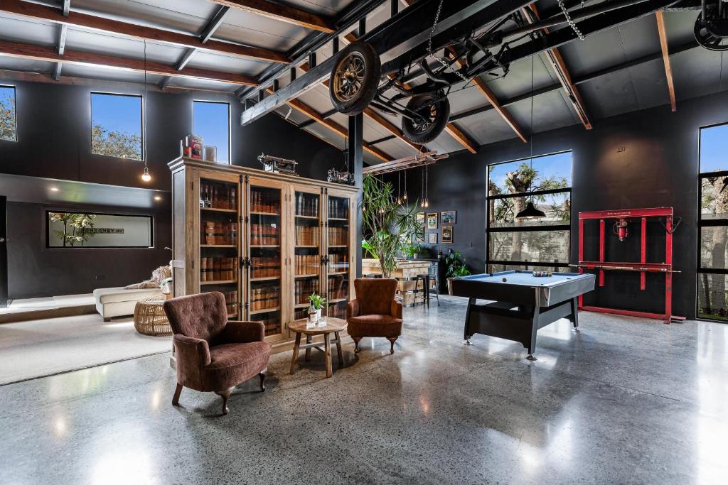 een woonkamer met een pooltafel en stoelen bij The Black Barn in Auckland