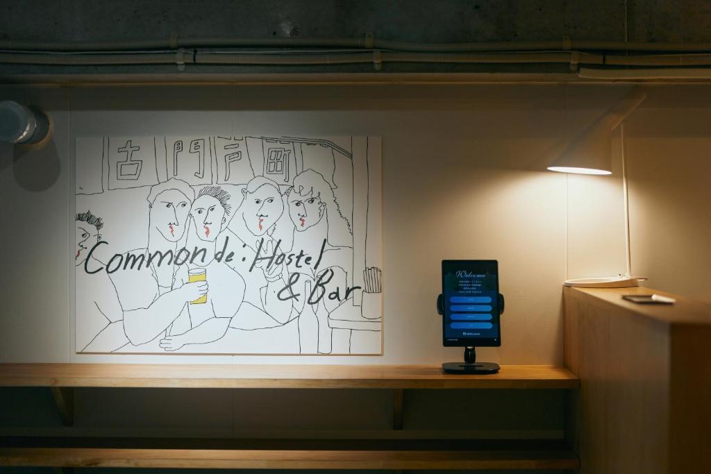 a wall with a drawing of a group of people at Common de - Hostel & Bar in Fukuoka