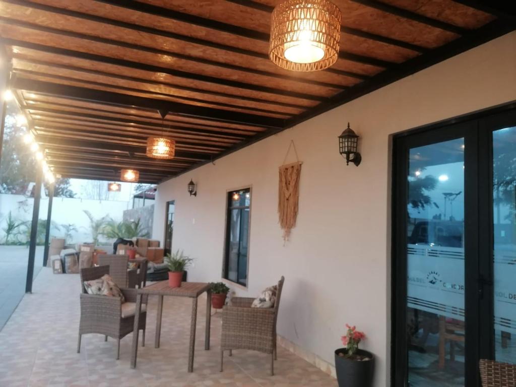 un patio con mesa, sillas y una lámpara de araña en Hotel Sol de Ocucaje, en Ica